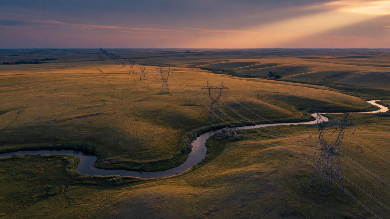 Aerial view of South Dakota prairie at dusk with distant transmission infrastructure